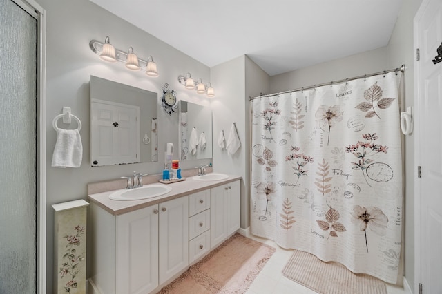 full bath with a sink, tile patterned floors, a shower with curtain, and double vanity