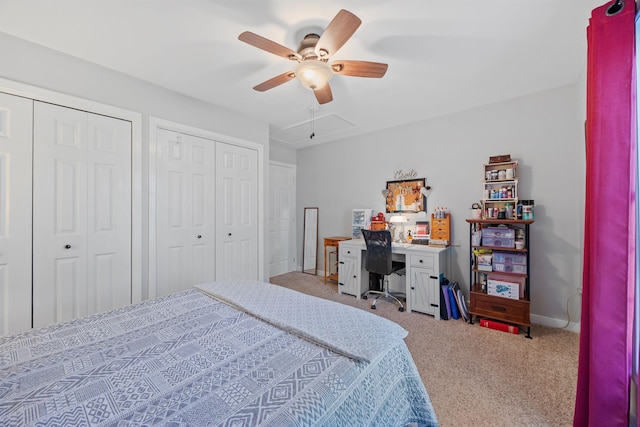 carpeted bedroom featuring baseboards, attic access, multiple closets, and ceiling fan