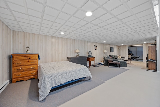 bedroom with baseboard heating, recessed lighting, carpet, and wooden walls