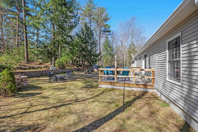 view of yard featuring a deck and a fire pit