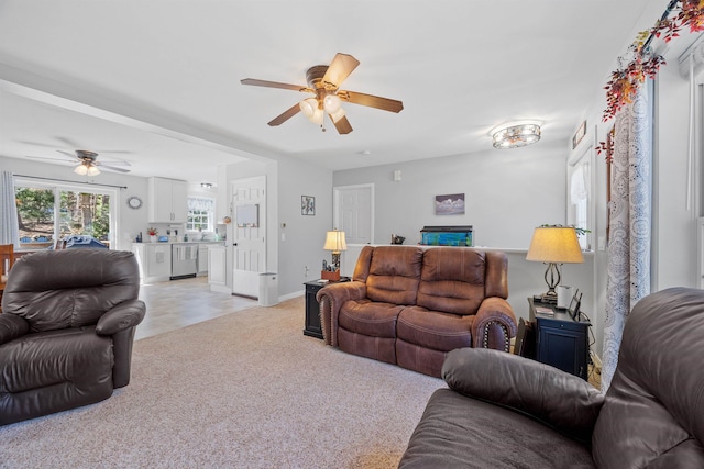 living room featuring baseboards, ceiling fan, and light carpet