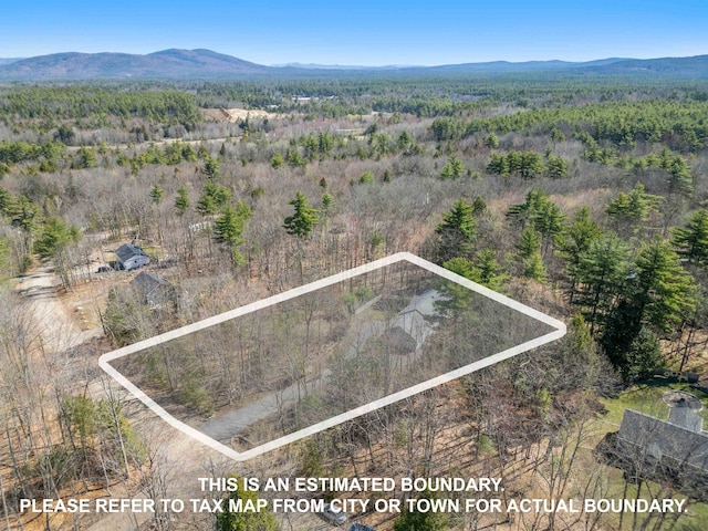 birds eye view of property featuring a wooded view and a mountain view