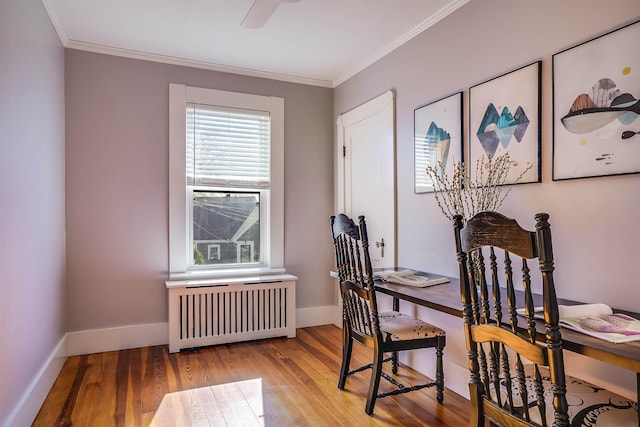 office space with baseboards, ornamental molding, radiator heating unit, and hardwood / wood-style flooring