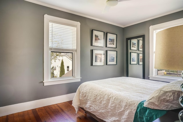 bedroom with crown molding, multiple windows, and wood finished floors