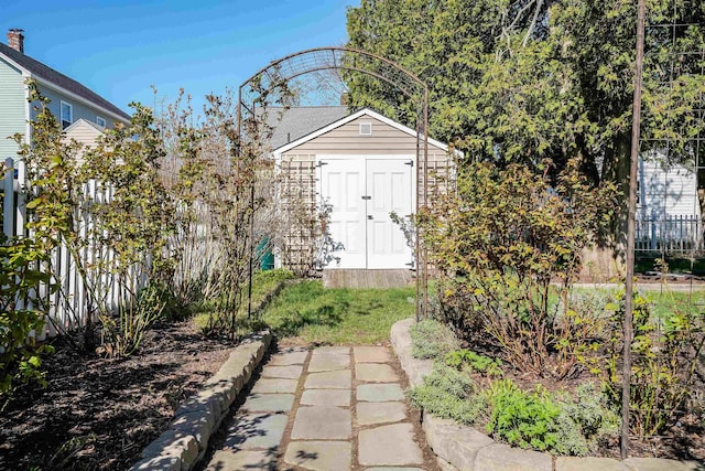 view of yard featuring a storage shed, fence, and an outbuilding