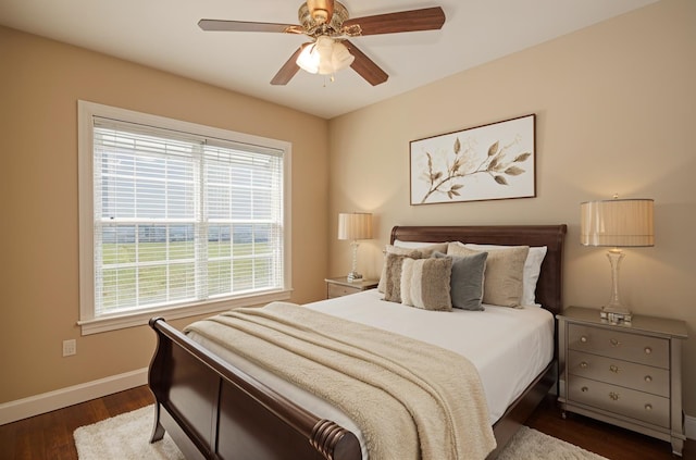 bedroom with baseboards, a ceiling fan, dark wood-style floors, and multiple windows