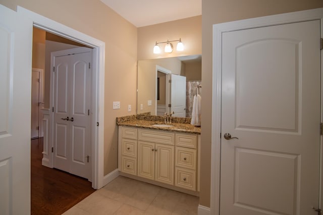 full bathroom featuring baseboards, tile patterned floors, and vanity