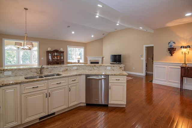 kitchen with a sink, stainless steel dishwasher, a fireplace, and dark wood finished floors