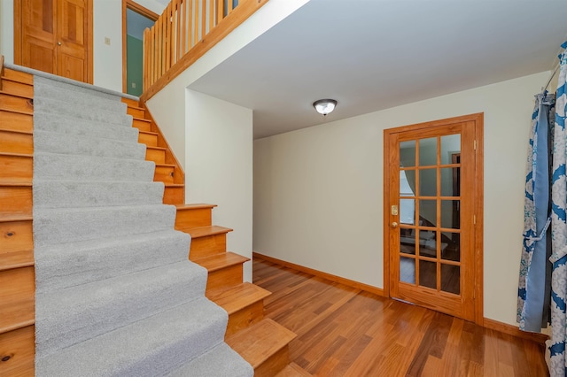 staircase with baseboards and wood finished floors