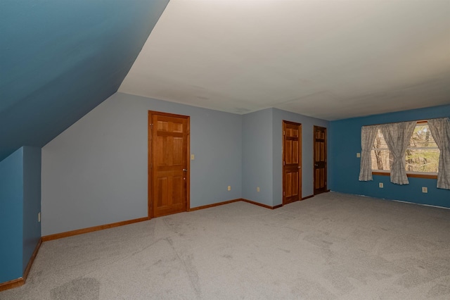 additional living space with baseboards, carpet, and vaulted ceiling