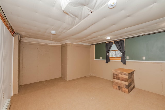 below grade area with carpet floors and a baseboard heating unit
