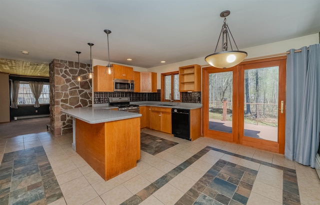 kitchen with appliances with stainless steel finishes, a sink, light countertops, a baseboard radiator, and a peninsula