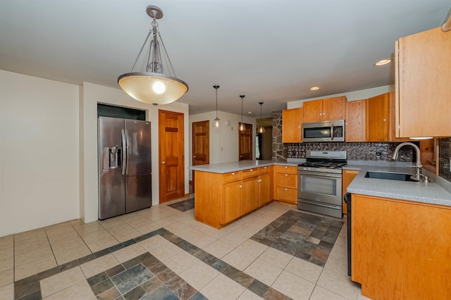 kitchen featuring backsplash, pendant lighting, appliances with stainless steel finishes, a sink, and a peninsula