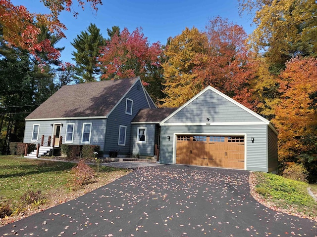 view of front facade with driveway, a front yard, and a garage