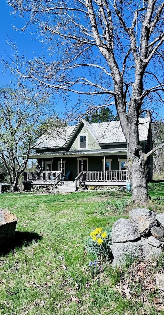 farmhouse inspired home with a porch and a front yard