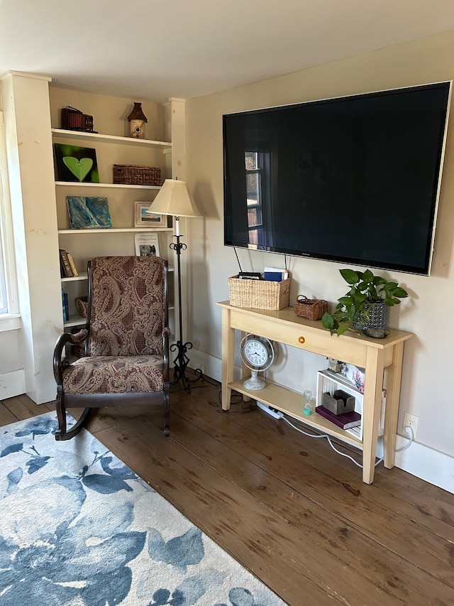 sitting room with baseboards and wood finished floors