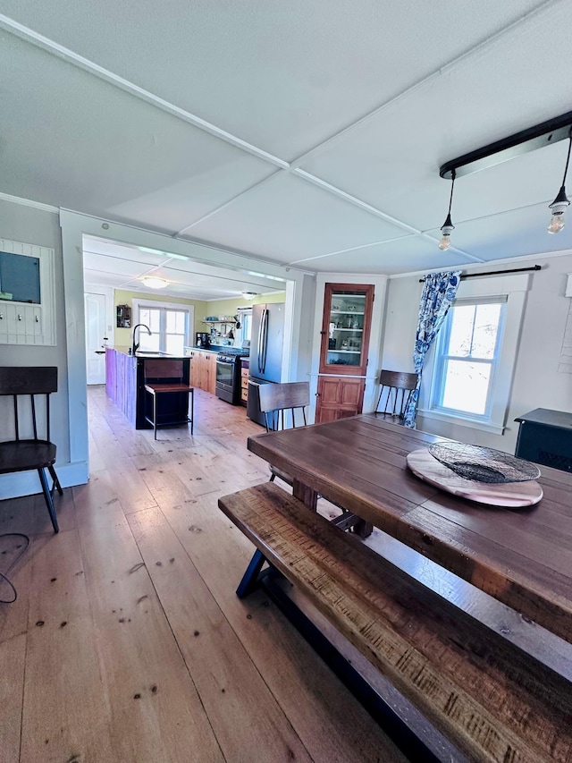 dining area with a ceiling fan and light wood-style flooring