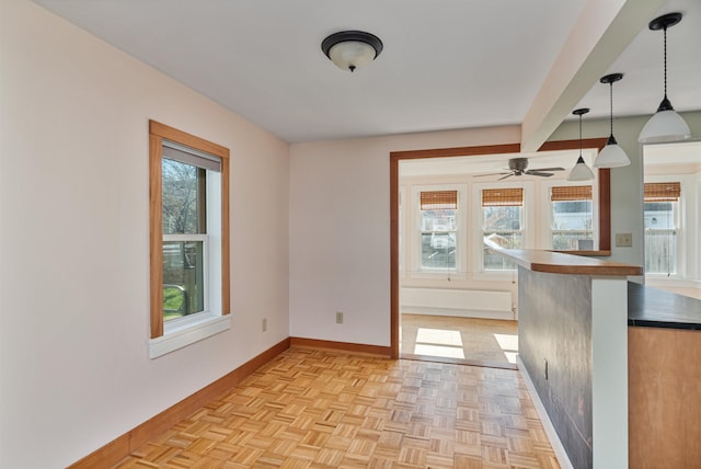 unfurnished room with baseboards, ceiling fan, and a healthy amount of sunlight