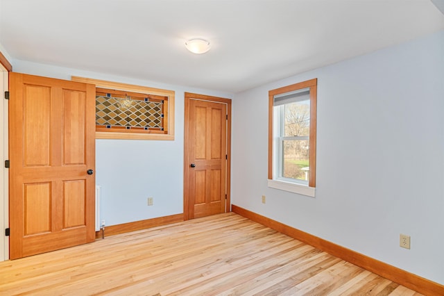 unfurnished room with light wood-style floors and baseboards