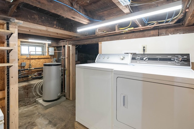 clothes washing area featuring washing machine and clothes dryer, laundry area, and gas water heater