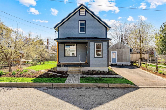 american foursquare style home featuring fence and covered porch