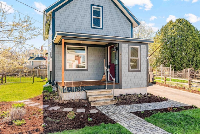 view of front facade featuring fence, a porch, and a front yard