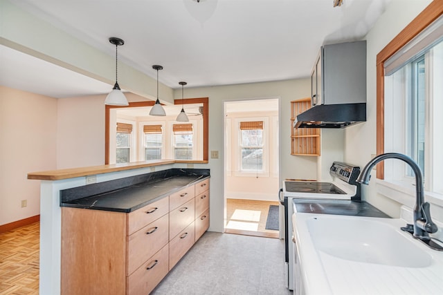 kitchen with light brown cabinetry, baseboards, white electric range, a sink, and hanging light fixtures