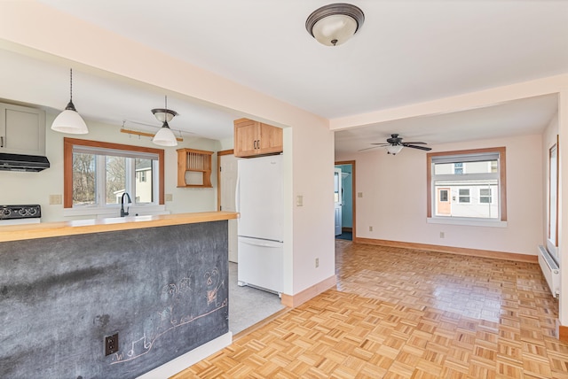 kitchen featuring wood counters, extractor fan, stove, freestanding refrigerator, and baseboards