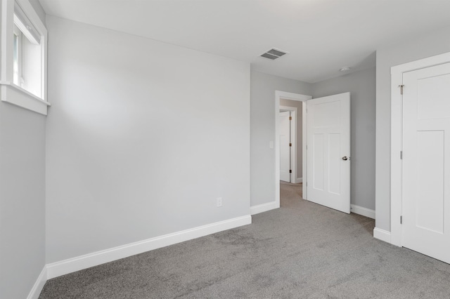 unfurnished bedroom featuring carpet floors, baseboards, and visible vents