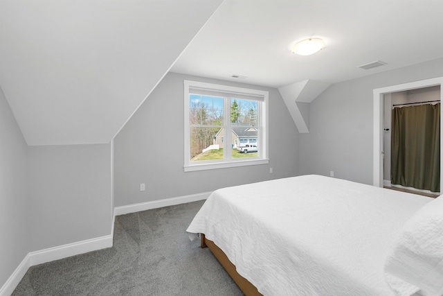 bedroom with baseboards, visible vents, dark carpet, and lofted ceiling