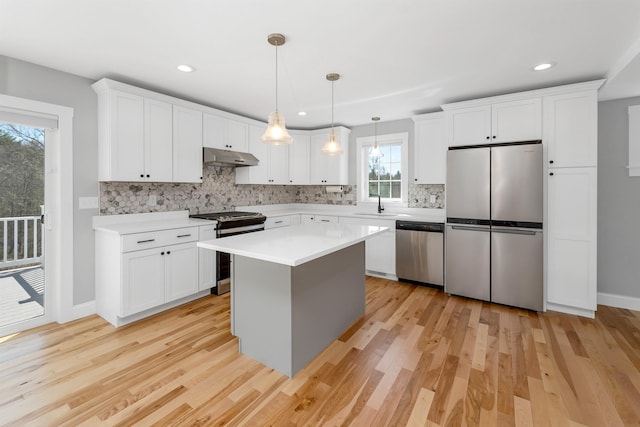 kitchen featuring a sink, appliances with stainless steel finishes, light wood-style floors, and backsplash