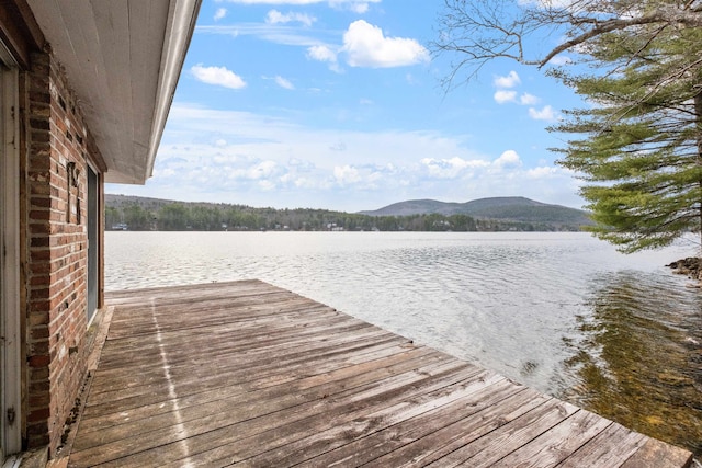 view of dock with a water and mountain view