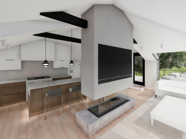 interior space featuring light wood finished floors, decorative light fixtures, a kitchen bar, vaulted ceiling, and modern cabinets