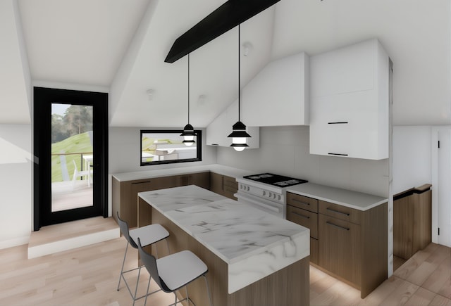 kitchen with pendant lighting, modern cabinets, a kitchen breakfast bar, a center island, and light wood-style flooring