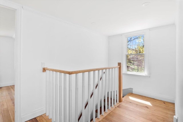staircase featuring baseboards, ornamental molding, and wood finished floors