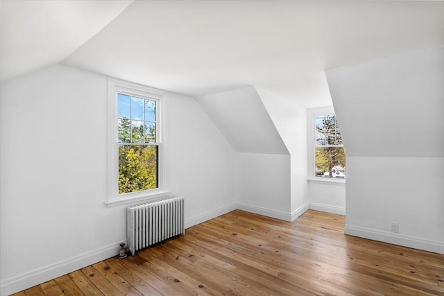 bonus room featuring radiator, baseboards, hardwood / wood-style flooring, and lofted ceiling