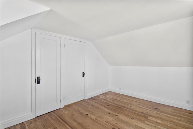 bonus room featuring baseboards, wood finished floors, and lofted ceiling