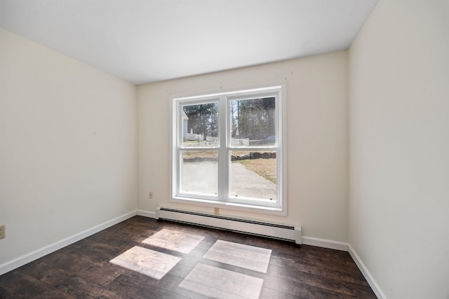 spare room with baseboards, a baseboard radiator, and dark wood finished floors