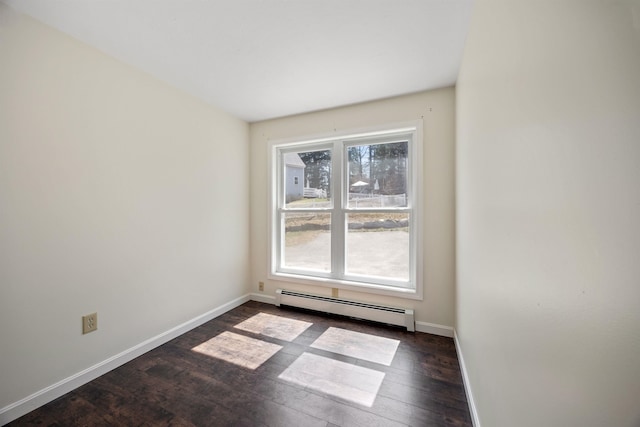 spare room with baseboards, dark wood-style flooring, and a baseboard heating unit