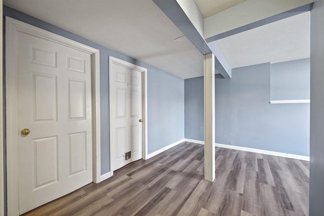 additional living space with baseboards and wood finished floors