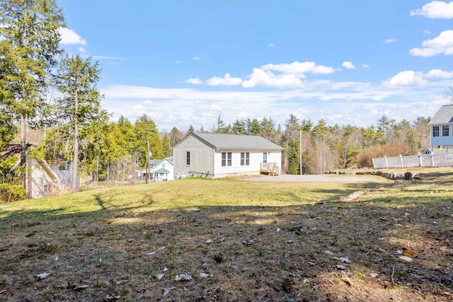 view of home's exterior with fence and a yard