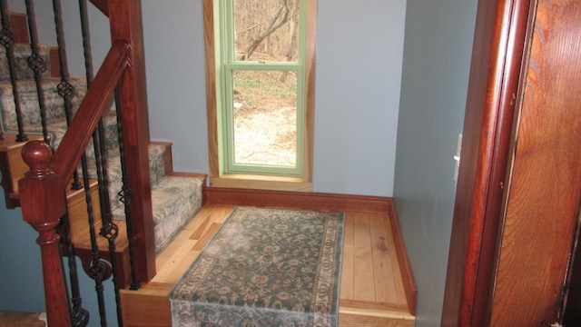 staircase with baseboards and wood finished floors