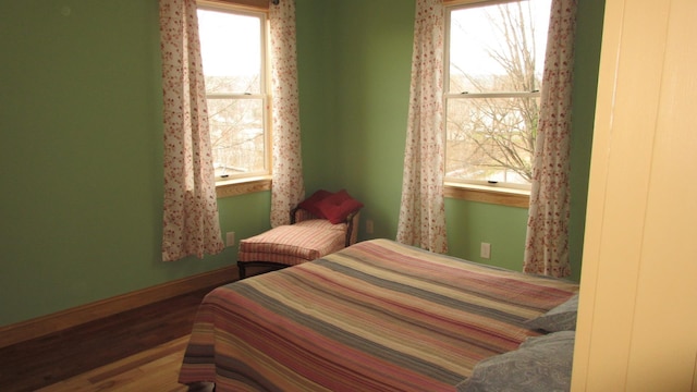 bedroom featuring baseboards and wood finished floors