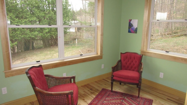 sitting room featuring plenty of natural light, baseboards, and wood finished floors