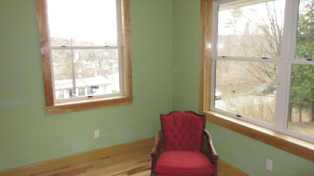 living area with baseboards and wood finished floors