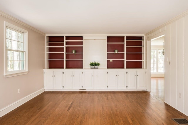 interior space featuring crown molding, plenty of natural light, and wood finished floors