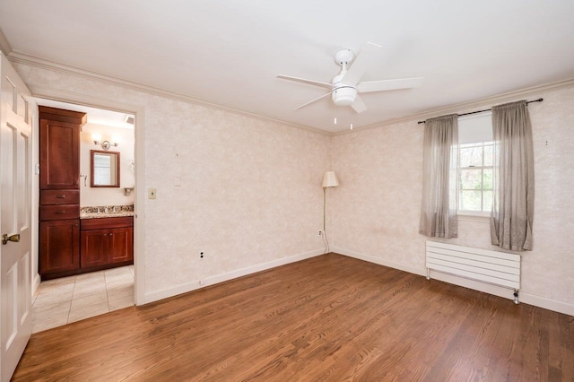 unfurnished room with a ceiling fan, light wood finished floors, radiator heating unit, and ornamental molding