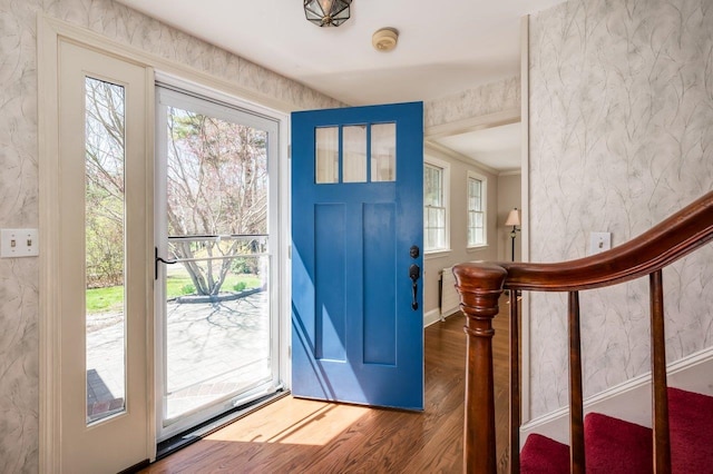entrance foyer featuring baseboards, wood finished floors, and stairway