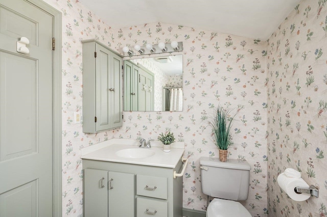 full bathroom with vanity, toilet, and wallpapered walls