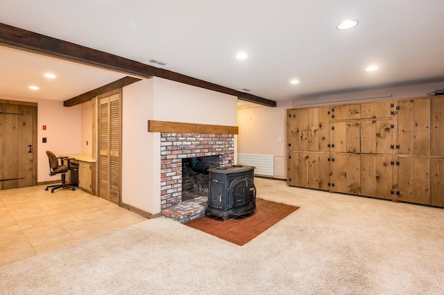 carpeted living room with recessed lighting, a wood stove, beam ceiling, and visible vents